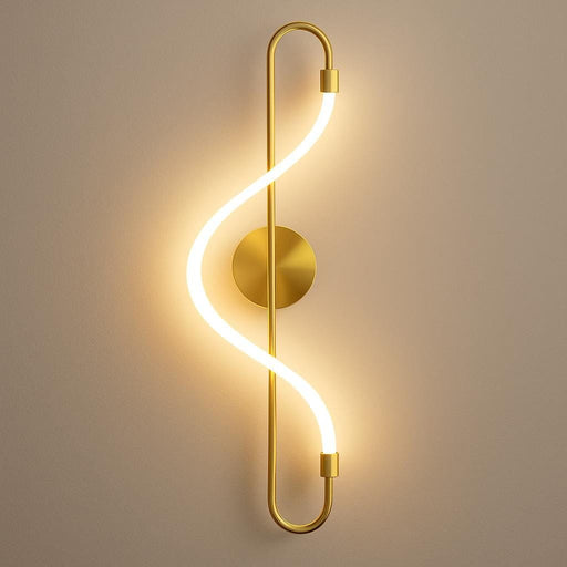 A close-up of the Iris Wall Light in luxurious matt gold, mounted on a modern living room wall, emitting a soft warm white glow, with a sleek and sculptural S-shaped LED strip design highlighted under subtle ambient lighting.