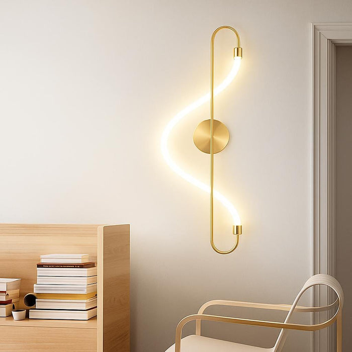 A lifestyle scene featuring the Iris Wall Light in matte gold, accentuating a cozy reading nook with modern furniture, with the light casting a gentle glow that enhances the elegant and warm atmosphere.