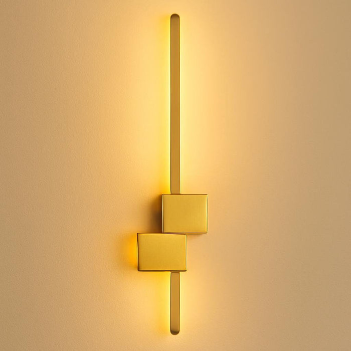 A close-up of the Arlo Gold Wall Light mounted on a modern living room wall, highlighting its sleek matte gold finish and minimalist linear design, with warm ambient lighting creating a cozy atmosphere.