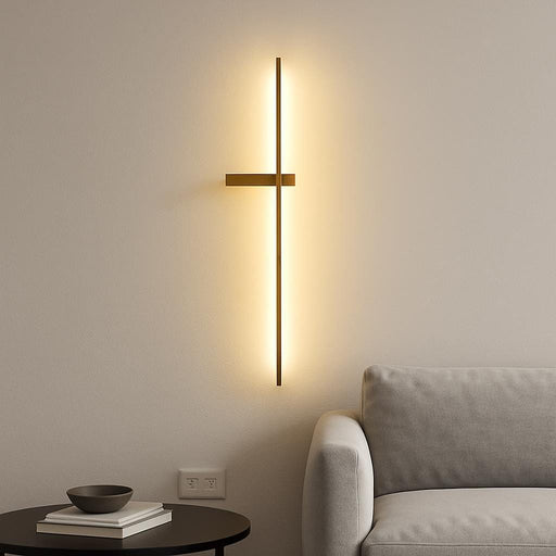 A sleek modern interior with the Dario LED gold wall light mounted on a minimalist white wall, casting a warm ambient glow in a living room setting, emphasizing the luxurious matte gold finish and linear design.