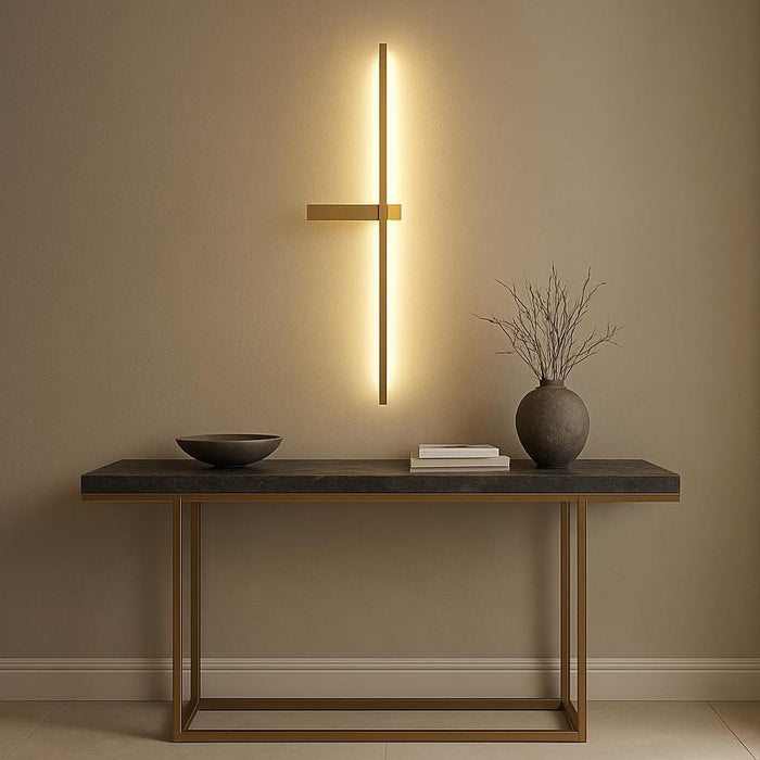 Elegant entryway scene featuring the Dario LED gold wall light installed above a modern console table, showcasing its architectural inspired design and warm white illumination that enhances the sophisticated ambiance.